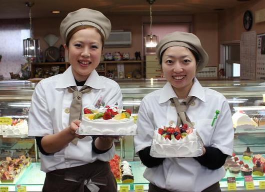 ホールケーキを持ったスタッフ